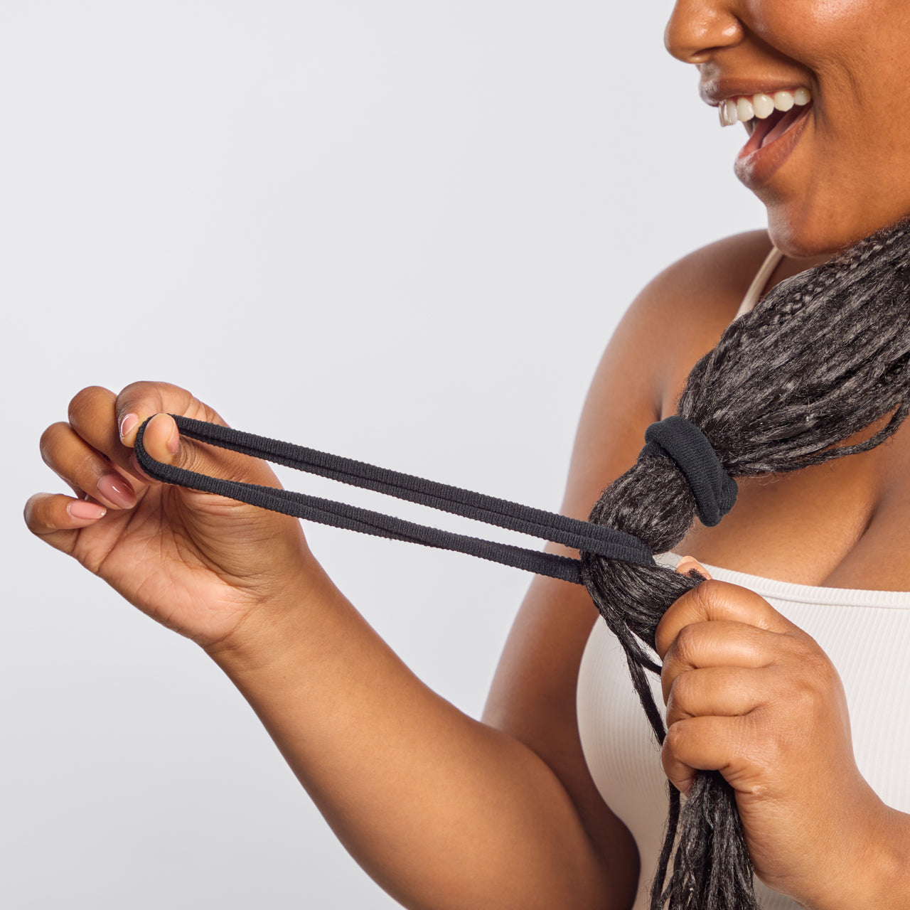 Smiling model with dreadlocks stretching Kitsch Recycled Nylon Thick Elastic in Black